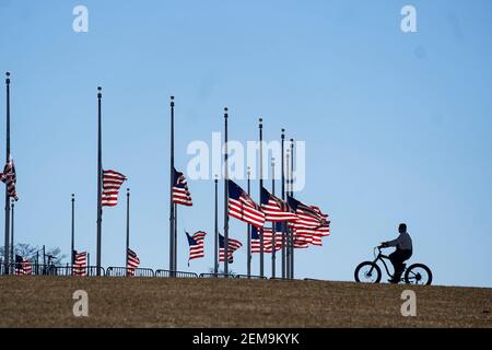 Washington, USA. Februar 2021, 24th. US-Nationalflaggen fliegen auf Halb-Mitarbeiter am Washington Monument, um die mehr als eine halbe Million US-Menschenleben zu betrauern, die COVID-19 am 24. Februar 2021 in Washington, DC, USA, verloren hat. Quelle: Liu Jie/Xinhua/Alamy Live News Stockfoto