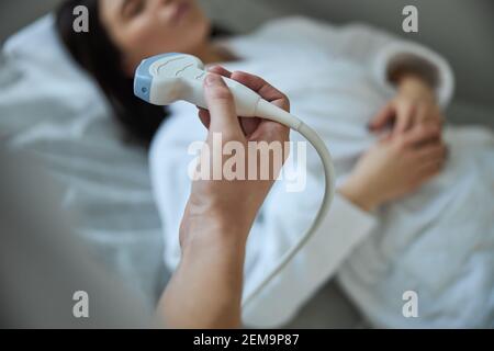 Arzt, der eine Ultraschalluntersuchung mit einem Ultraschallaufnehmer durchführt Stockfoto