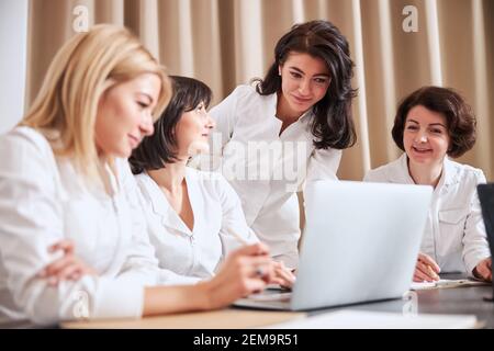 Gruppe von vier Mitarbeitern im Gesundheitswesen, die ihre Patientenfälle diskutieren Stockfoto