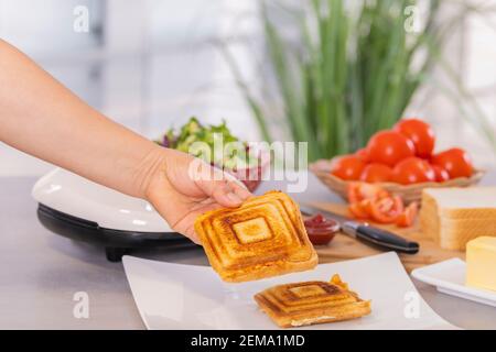 Ein köstliches gegrilltes Käse- und Schinken-Sandwich auf einem Teller auf einem unscharf Hintergrund. Selektiver Fokus und Nahaufnahme. Food-Konzept. Stockfoto