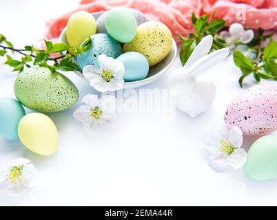 Bunte Ostereier mit Frühlingsblüten Blüten isoliert auf weißem Hintergrund. Farbige Eier Feiertagsgrenze. Stockfoto