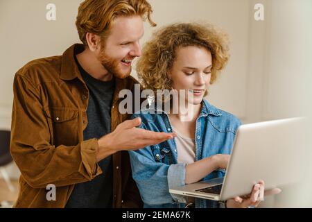 Geschäftspartner, die an einem Laptop arbeiten, während sie im stehen Büro Stockfoto