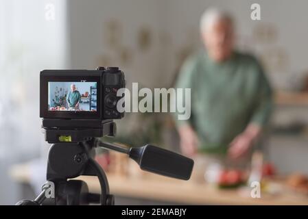 Senior Food Blogger schießen vor der Kamera sein Blog über Essen In der Küche Stockfoto