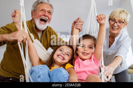 Enkelkinder, die Spaß haben, spielen mit Großeltern zu Hause Stockfoto