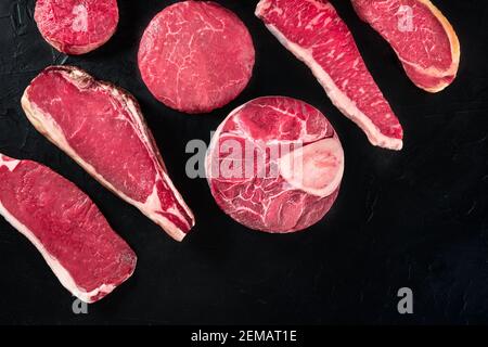 Rohe Fleischstücke aus Rindfleisch, Top-Shot mit einem Platz für Text, auf schwarzem Hintergrund Stockfoto