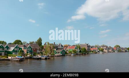 Schöne traditionelle holländische Häuser am Ufer des Flusses zaan, in den Vororten von Amsterdam in den Niederlanden. Stockfoto