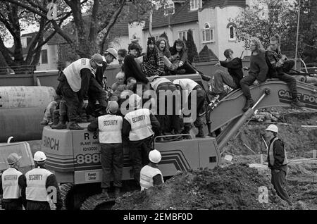 Die Sicherheitskräfte versuchen, auf dem Gelände der M11 Link Road im Osten Londons Demonstranten zu entfernen, die Straßenfeinde besetzen. Die Maschinen wurden besetzt, um den Straßenbau zu stoppen. Die Proteste dauerten 2 Jahre und endeten damit, dass sich die Kosten des Straßenverkehrskonzeptes fast verdoppelten. Stockfoto