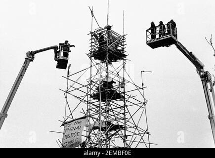 Gerichtsvollzieher in Kirschpflücker versuchen, Demonstranten von einem großen Turm aus Gerüsten über einem Haus in Claremont Road, East London, zu vertreiben. Der 100ft hohe Turm war Teil der Blockade, um gegen den Bau der M11 Link Road zu protestieren, und die Demonstranten blieben 5 Tage im Turm im November 1994 Stockfoto