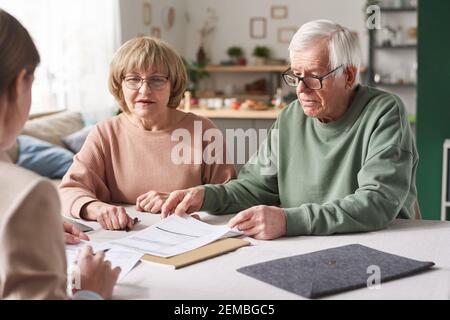 Senior paar Beratung über finanzielle Dokumente mit Berater sie haben Ein Treffen zu Hause Stockfoto