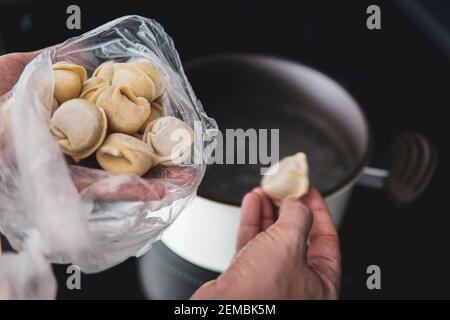Die Knödel aus dem Teig mit Fleisch werden in kochendem Wasser gekocht. Food-Foto. Das kulinarische Gericht Ukrainische Knödel. Stockfoto