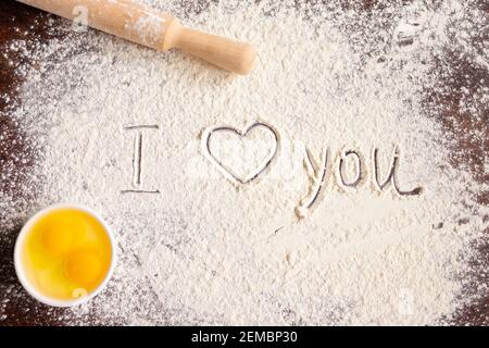 Die Inschrift Ich liebe dich auf bestreut Mehl, Nudelholz und Eier. Backrezepte. Valentinstag-Konzept. Liebeserklärung . Hochwertige Fotos Stockfoto