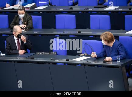 Berlin, Deutschland. Februar 2021, 25th. Olaf Scholz (l, SPD), Bundesminister der Finanzen, und Bundeskanzlerin Angela Merkel (CDU) sprechen während der Plenarsitzung im Deutschen Bundestag. Die Hauptthemen der Sitzung 212th der Legislaturperiode 19th sind der EU-Haushalt, das Arbeitsprogramm der EU-Kommission, die Frauenquote für Unternehmensvorstände, die Verlängerung des vereinfachten Planungsgesetzes und Corona-Schnelltests. Quelle: Bernd von Jutrczenka/dpa/Alamy Live News Stockfoto