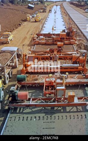 Archiv 1986 Luftaufnahme der Auftragnehmer Arbeiter auf Betonstraße Verlegemaschinen im Tiefbau Transportinfrastruktur Baustellengebäude Eine neue A12 Fernstraße Umgehung zweispurige Autobahn Autobahn Route Umgehung der Stadt Chelmsford mit Polythenmembran in Position In Essex England UK ein historisches Archivbild aus dem Jahr 1980s Hüte und Jacken mit hoher Sichtbarkeit Stockfoto