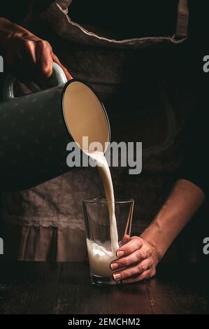 Frau Bäuerin mit einem Glas Milch. Konzeptprobleme im Agrarsektor. Stockfoto