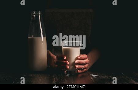 Frau Bäuerin mit einem Glas Milch. Konzeptprobleme im Agrarsektor. Stockfoto