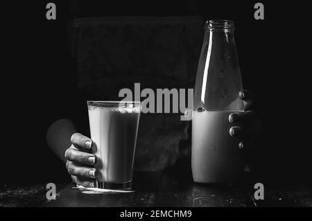 Frau Bäuerin mit einem Glas Milch. Konzeptprobleme im Agrarsektor. Stockfoto