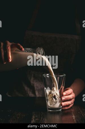 Frau Bäuerin mit einem Glas Milch. Konzeptprobleme im Agrarsektor. Stockfoto