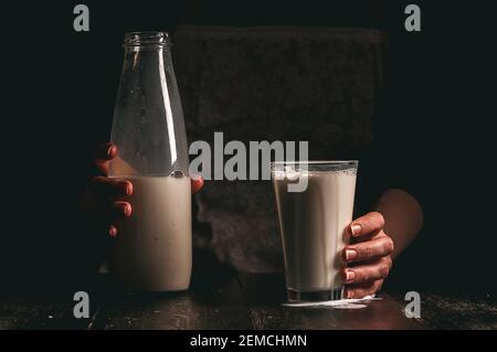 Frau Bäuerin mit einem Glas Milch. Konzeptprobleme im Agrarsektor. Stockfoto