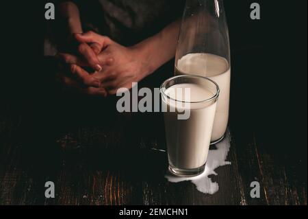 Frau Bäuerin mit einem Glas Milch. Konzeptprobleme im Agrarsektor. Stockfoto