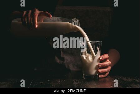 Frau Bäuerin mit einem Glas Milch. Konzeptprobleme im Agrarsektor. Stockfoto