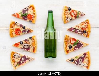 Frische Pizza im rustikalen italienischen Stil mit ruckigen Oliven Die Pilze und drei Arten des Käses auf dem hellen hölzernen Hintergrund mit einer Flasche kaltes Bier Stockfoto