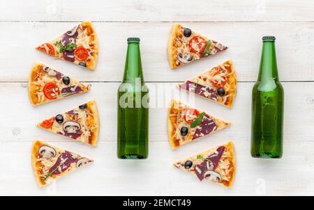 Frische Pizza im rustikalen italienischen Stil mit ruckigen Oliven Die Pilze und drei Arten des Käses auf dem hellen hölzernen Hintergrund mit einer Flasche kaltes Bier Stockfoto