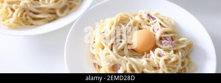 Auf dem Tisch sind drei Teller Spaghetti Carbonara mit pochiert Eigelb Stockfoto