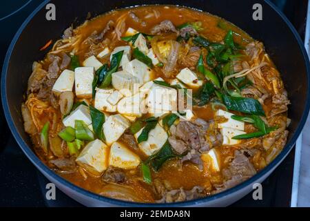 Eine Pfanne mit köstlicher, würziger koreanischer Kimchi jjigae-Suppe und Tofu Stockfoto