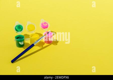 Satz Acrylfarbe mit Pinsel auf gelbem Hintergrund Stockfoto