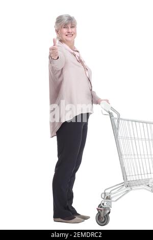 Ältere Dame mit einem Einkaufswagen, die Sie mit einem Lächeln anschaut. Stockfoto