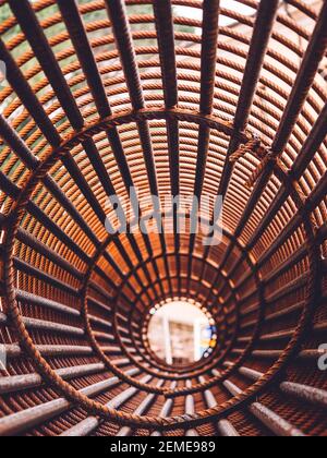 Bügeleisen auf der Baustelle. Rosty Circle Iron Bundle für die Herstellung von Stahlbeton und Kunststoff orange Netz. Innenansicht des Rebars für verstärktes Loch Stockfoto