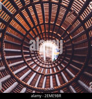 Bügeleisen auf der Baustelle. Rosty Circle Iron Bundle für die Herstellung von Stahlbeton und Kunststoff orange Netz. Innenansicht des Rebars für verstärktes Loch Stockfoto