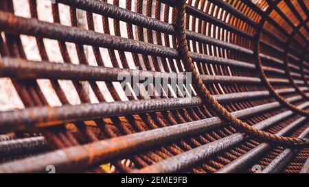 Bügeleisen auf der Baustelle. Rosty Circle Iron Bundle für die Herstellung von Stahlbeton und Kunststoff orange Netz. Innenansicht des Rebars für verstärktes Loch Stockfoto