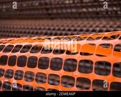 Bügeleisen auf der Baustelle. Rosty Iron Bundle für die Herstellung von Stahlbeton und Kunststoff orange Netz. Retriegel für Verstärkung Loch im Boden. Textur Stockfoto