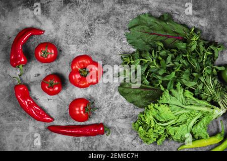 Tomaten, Paprika und Grünpflanzen auf dem Marmorhintergrund Stockfoto