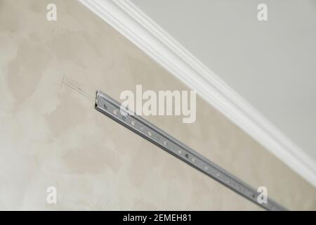 Nahaufnahme der Edelstahl-Montageschiene zur Montage von Küchenschränken an einer Wand. Stockfoto