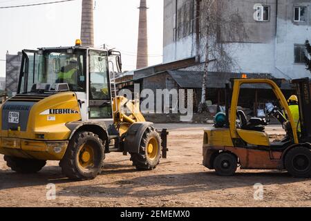 LUTSK, UKRAINE - 10. Mai 2020: Gelbe Radlader Baggermaschine im Sägewerk. Stockfoto