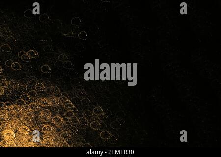 Schwarze Oberfläche mit kreisförmigen Gold-Texturen von Licht mit langer Verschlusszeit bei Nacht; Farbfoto, No,1. Stockfoto
