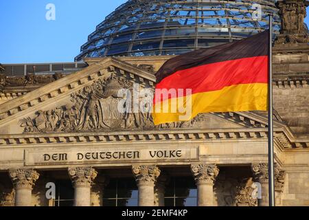 Die deutsche Flagge vor dem Reichstagsgebäude in Berlin. Die Inschrift sagt: Dem Deutschen Volk - dem deutschen Volk. Stockfoto