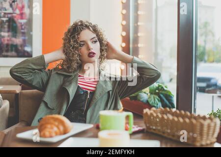 Elegante Frau, die im Straßencafé der Stadt sitzt Stockfoto