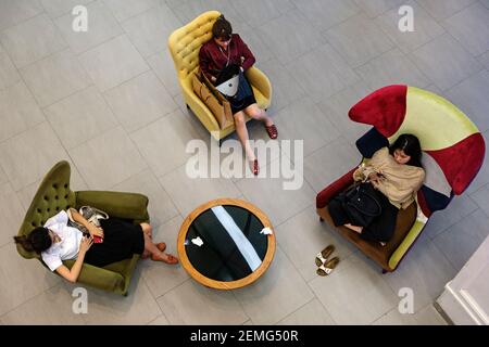 Junge Frauen entspannen im Siam Center Einkaufszentrum in Bangkok, Thailand Stockfoto