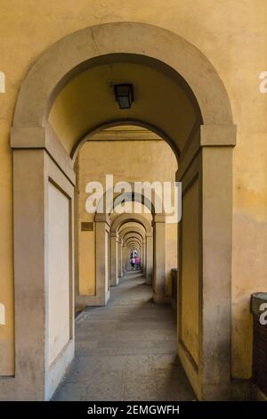 Toller Blick auf den gewölbten Durchgang unterhalb des berühmten Vasari-Korridors in Florenz entlang des Flusses Arno, der die Brücke Ponte Vecchio mit dem... Stockfoto