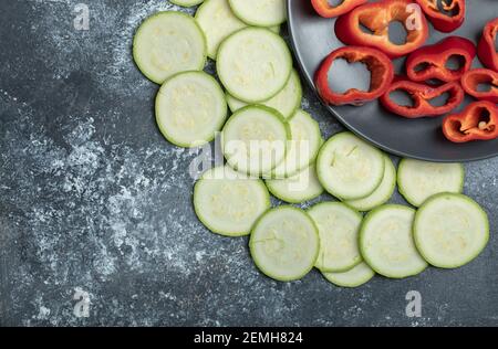 Paprika in Scheiben und Zucchini auf Marmorboden Stockfoto