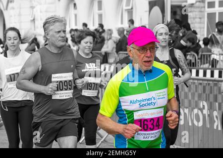Senior Mann trägt Alzheimer's Society Top-Rennen in Bournemouth Bay Laufen in Bournemouth, Dorset UK im April Stockfoto