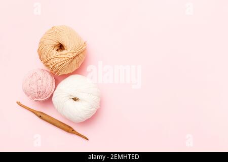 Grau und rosa Strickwolle und Stricknadeln auf weißem Holzhintergrund. Draufsicht.Copy Raum Stockfoto