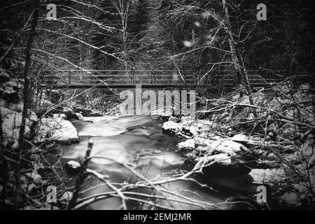 Moody Langzeitaufnahme von glattem Wasser und Brücke über den kleinen Fluss Jaran in Bispgarden, Schweden. Stockfoto