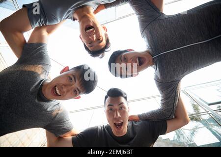Team von vier jungen asiatischen erwachsenen Athleten mit Spaß im Freien Stockfoto