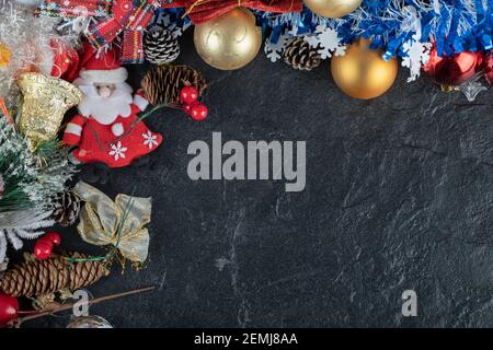 Bündel von Weihnachtsschmuck und Santa Figur auf dunklem Hintergrund Stockfoto