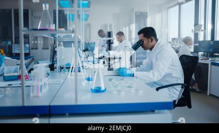 Modern Medical Research Laboratory: Diverse Team von Wissenschaftlern, die mit Pipette arbeiten, Biochemikalien-Proben analysieren, reden. Wissenschaftliches Labor für Stockfoto