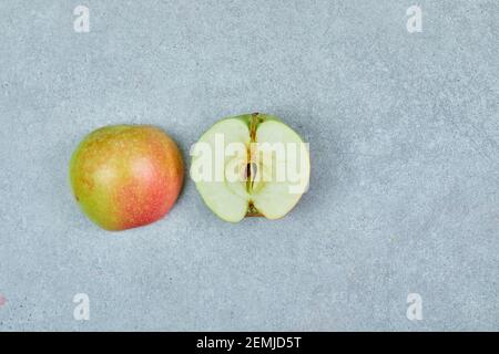 Frischer halbgeschnittener Apfel auf grauem Hintergrund Stockfoto